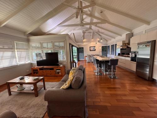 a large living room with a couch and a kitchen at Tropical cocoon with 2 bedrooms in Papeete
