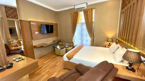 a hotel room with a large bed and a couch at Hotel Pondok Asri Boyolali in Boyolali