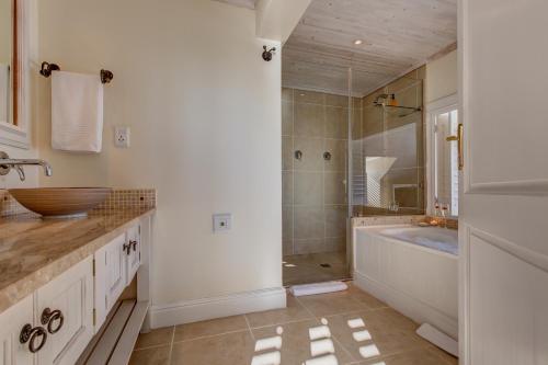 a bathroom with a tub and a sink and a shower at Amanzi Island Boutique Hotel in Knysna
