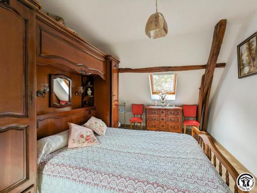 een slaapkamer met een houten bed en een dressoir bij Au cabanous in Boutx