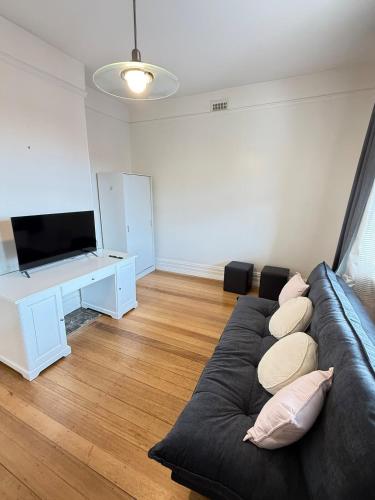 un salon avec un canapé et une télévision à écran plat dans l'établissement Central Sandy Bay Retreat, à Sandy Bay