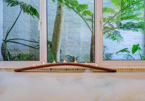 a room with a window with a tree and candles at Amanzi Island Boutique Hotel in Knysna