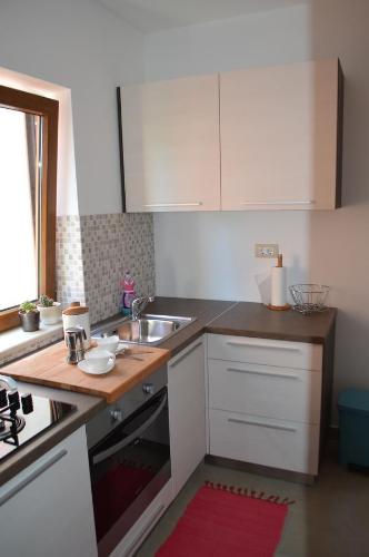 kuchnia z białymi szafkami i zlewem w obiekcie Apartment Bozac w Rovinj