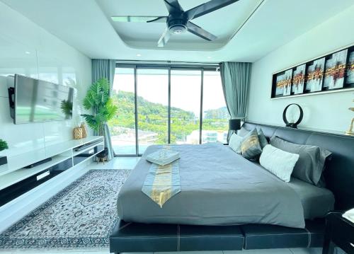 a bedroom with a large bed and a flat screen tv at Twin Sands Resort Penthouse in Patong Beach