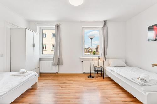 a white room with two beds and a window at GÜNSTIGE Wohnung für Monteure in Merklingen, WiFi, Smart TV, Parkplatz in Merklingen
