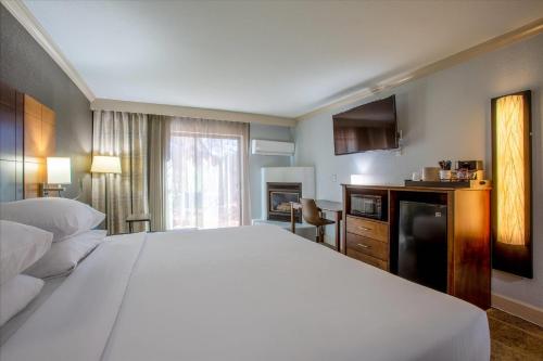 a bedroom with a large white bed and a television at Arroyo Pinion Hotel, an Ascend Collection Hotel in Sedona