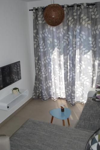 sala de estar con sofá y mesa frente a una ventana en Apartment Bozac, en Rovinj