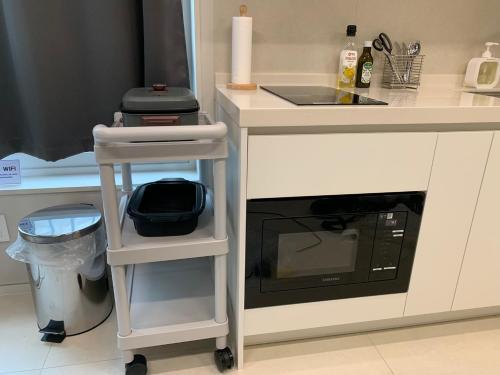 a kitchen counter with a microwave oven and a sink at Lotte Tower view terrace house in Seoul