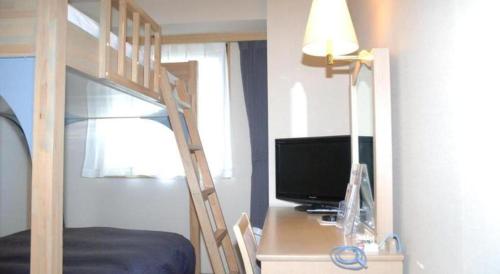 a bedroom with a bunk bed with a computer on a desk at Albert Hotel in Akita