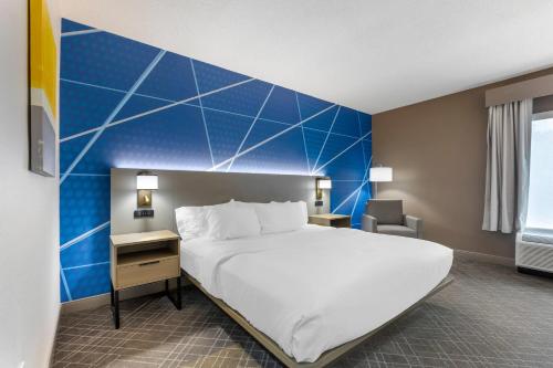 a bedroom with a large bed and a blue wall at Comfort Inn Blythewood - North Columbia in Blythewood
