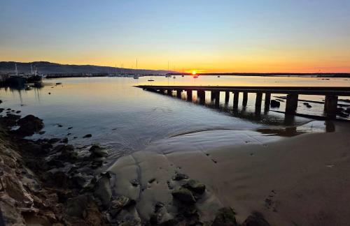 a sunset over a body of water with a pier at Seaview Motel & Apartments in Apollo Bay
