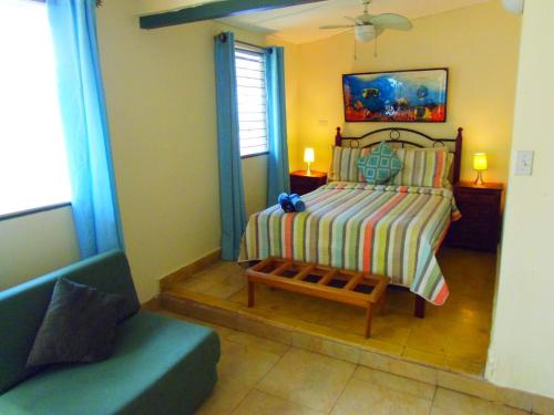 a bedroom with a bed and a bench and a couch at Casa del Sol Bed and Breakfast in Contadora