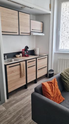 un salon avec un canapé et une cuisine dans l'établissement Escapade cœur de ville Narbonne, à Narbonne