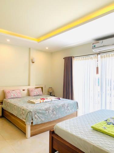 a bedroom with two beds and a window at Tonys House in Thôn An Hòa
