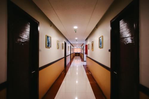 an empty hallway in a building with paintings on the walls at Surigao Royal Regency Suites in Surigao
