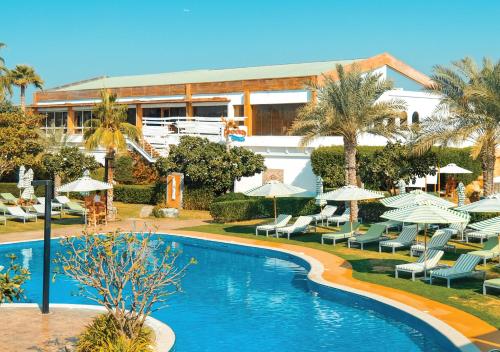a resort with a swimming pool with chairs and umbrellas at Dubai Marine Beach Resort & Spa in Dubai