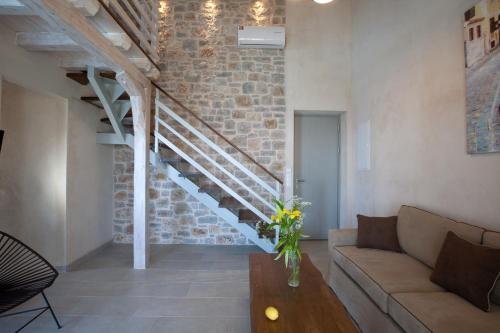 a living room with a couch and a staircase at Ionian Horizon Villas in Tsoukaladhes