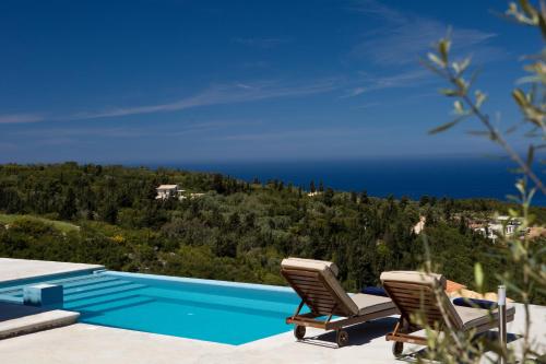 a swimming pool with two chairs and the ocean at Ionian Horizon Villas in Tsoukaladhes