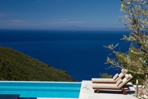 a wooden bench sitting next to a swimming pool at Ionian Horizon Villas in Tsoukaladhes