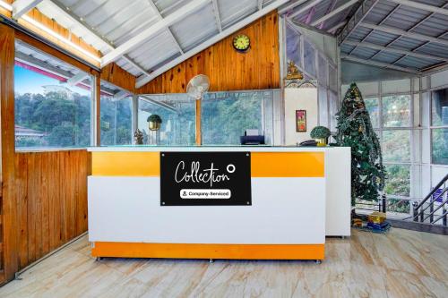 a lobby with a counter with a christmas tree in it at Collection O Mall Road Library Chowk in Mussoorie