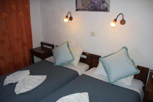 two beds in a room with blue and white pillows at Violetta Hotel in Amoudara Herakliou