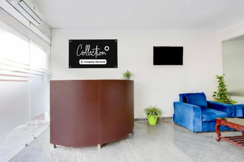 a living room with a blue couch and a sign at Collection O Sector 1 Manesar in Gurgaon