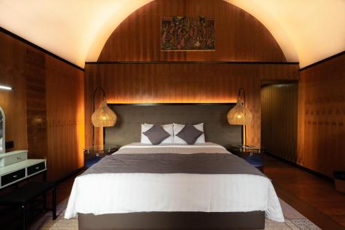 a bedroom with a large bed and two lamps at Pondanu Living in Bedugul