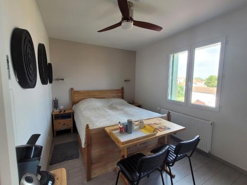 une chambre avec un lit et une table avec des chaises dans l'établissement Tout prêt, tout près du fort, à Saint-Georges-dʼOléron