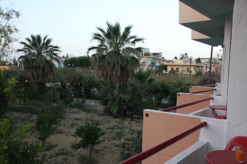 a view from a balcony of a yard with palm trees at Violetta Hotel in Amoudara Herakliou