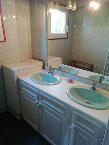 La salle de bains est pourvue de 2 lavabos, d'un miroir et de toilettes. dans l'établissement La Casa d'Annick, à Moliets-et-Maa