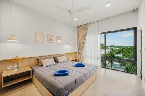a bedroom with a large bed with a large window at RYANNA Samui in Choeng Mon Beach