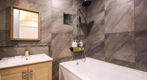 a bathroom with a sink and a tub and a mirror at Hotel Seowa in Gimhae