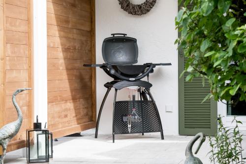 a tv sitting on a stool in front of a house at FENJOY Ferienapartments Bernau am Chiemsee in Bernau am Chiemsee