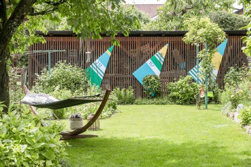 a hammock in a garden with flags on it at FENJOY Ferienapartments Bernau am Chiemsee in Bernau am Chiemsee