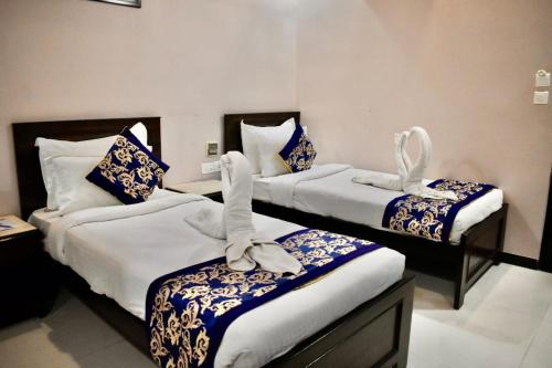 two beds in a hotel room with towels on them at Platinum Royal Excellency in Udaipur