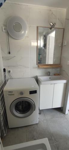 une petite salle de bains avec un lave-linge et un lavabo dans l'établissement Maison T3 clim bus C3 proche centre terrasse, à Avignon