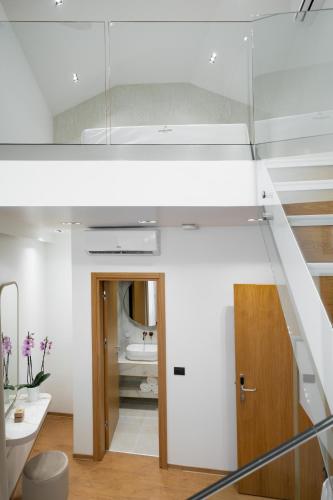 a white bathroom with a staircase and a sink at Aeolian Spirit Suites in Athens