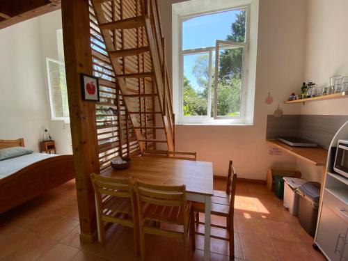 Cette chambre dispose d'une table en bois et d'un escalier en colimaçon. dans l'établissement Logement au calme entoure d un grand jardin, à Falleron