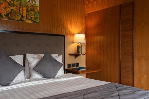 a bedroom with a bed and a lamp on a table at Pondanu Living in Bedugul