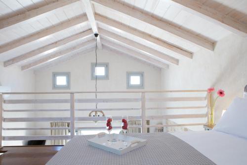 a white room with a table with a tray of flowers on it at Ionian Horizon Villas in Tsoukaladhes