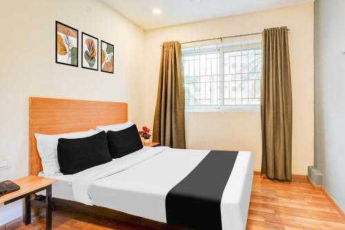 a bedroom with a large bed and a window at Townhouse Oak RNSIT RR nagar in Bengaluru