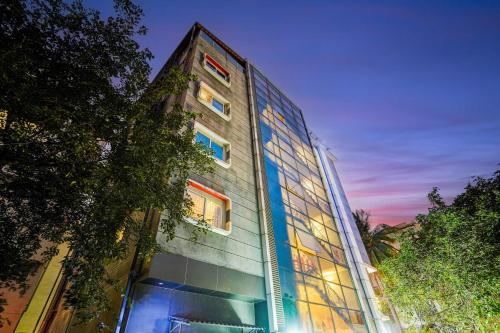 a tall glass building with colorful windows at night at Townhouse Oak RNSIT RR nagar in Bengaluru