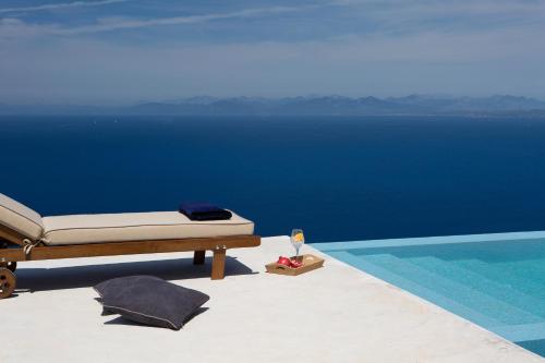 a bedroom with a bed next to a swimming pool at Ionian Horizon Villas in Tsoukaladhes