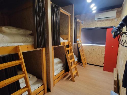 a room with several bunk beds in it at ｹﾞｽﾄﾊｳｽ ﾊﾞｲｸﾔﾉﾆｶｲ in Hagi