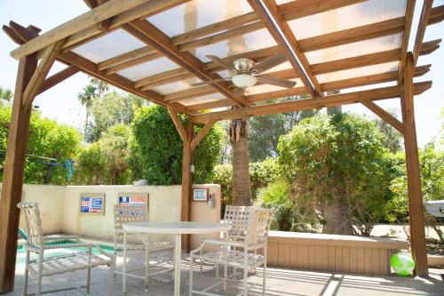 a wooden pergola with a table and chairs at The Inn at Deep Canyon in Palm Desert