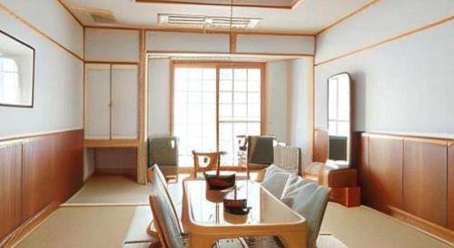 a room with a table and chairs in a room at Hotel Bellreef Otsuki in Otsuki