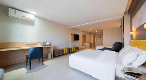 a hotel room with a bed and a desk and chairs at 7 Days Premium Xi'an Dayan Tower Xiaozhai Metro Station in Xi'an