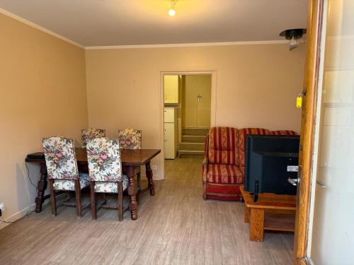 ein Wohnzimmer mit Tisch und Stühlen und einem Fernseher in der Unterkunft Logement des deux ponts in Sellières