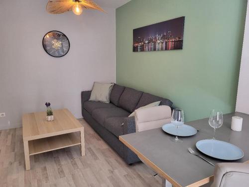 - un salon avec un canapé et une table avec des verres à vin dans l'établissement Renovated apartment, quiet, à Lyon