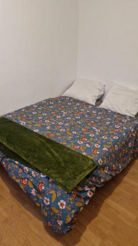 - un lit avec une couverture florale sur le sol dans l'établissement Studio 2-4 personnes, à Marseille